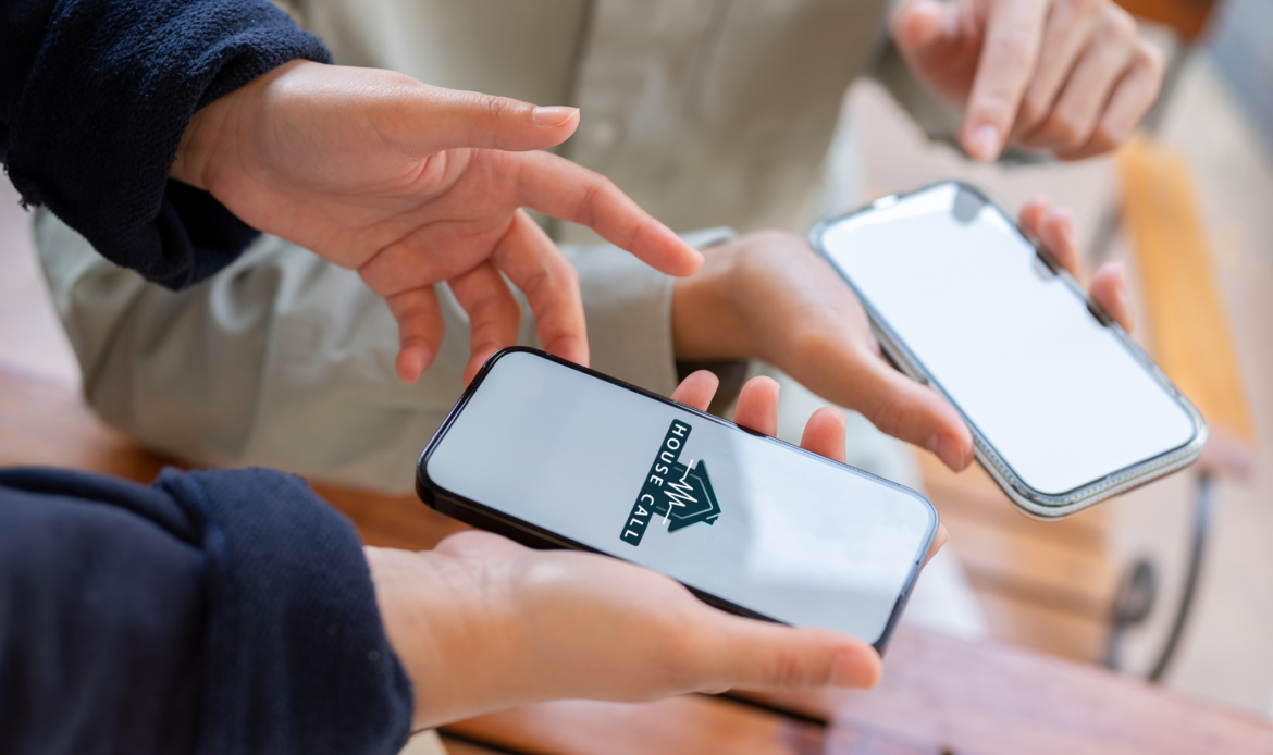 Close up of two phones in peoples' hands. On the phones is House Call The App, a mobile app for booking in home health and wellness visits.