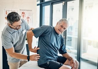 Physical therapy being done at home. Image shows physical therapist assisting patient at home.